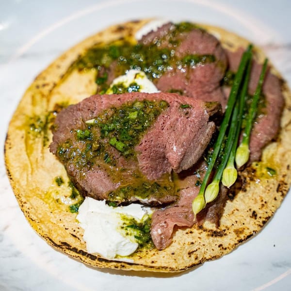 Rene's Mexican Kitchen's carne asada taco with green sauce, crema, and green onions.