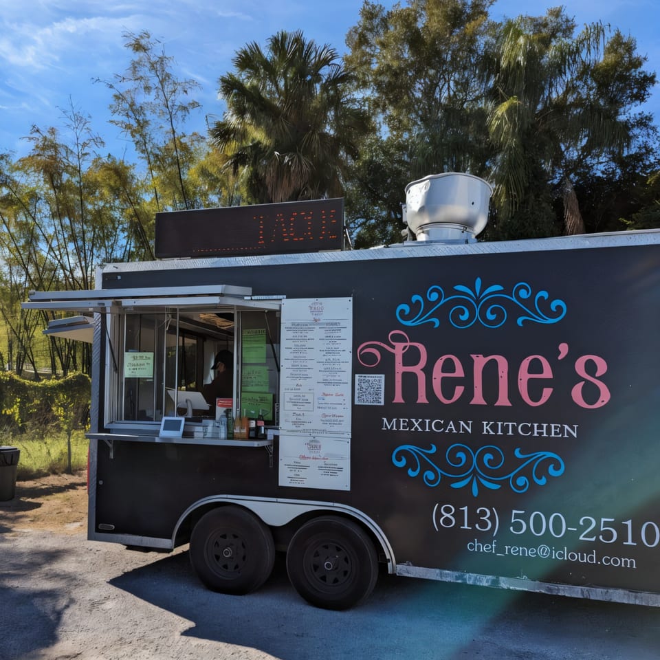 Rene's Mexican Kitchen food truck, black with pink and blue lettering, parked outdoors under a blue sky.